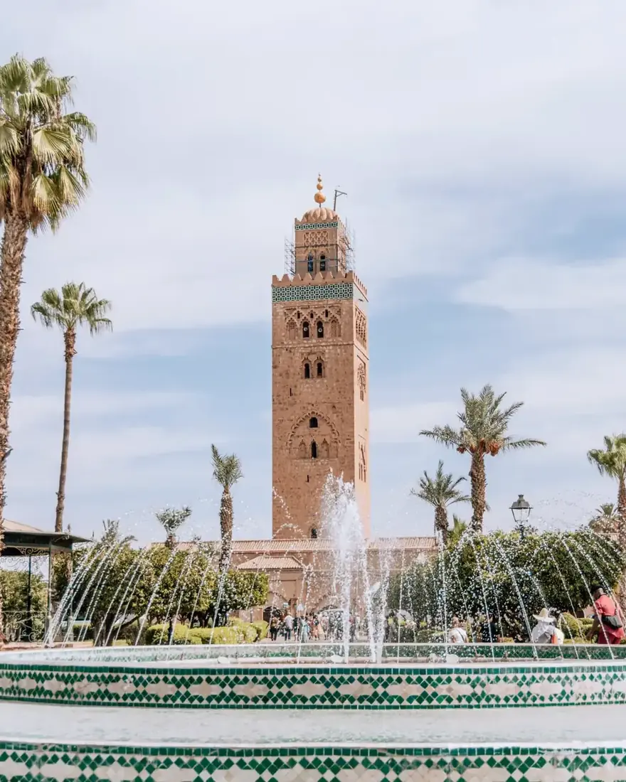 Minarete de la Koutoubia y fuente entre palmeras en Marrakech